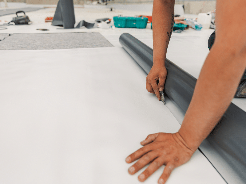 Roofer cutting to size TPO roofing sheets