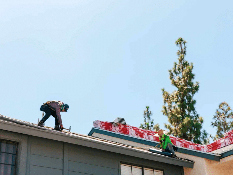 Workers from RENCO Roofing replacing a roof after insurance claim