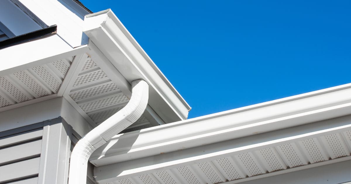 Newly installed white gutters on two-story home