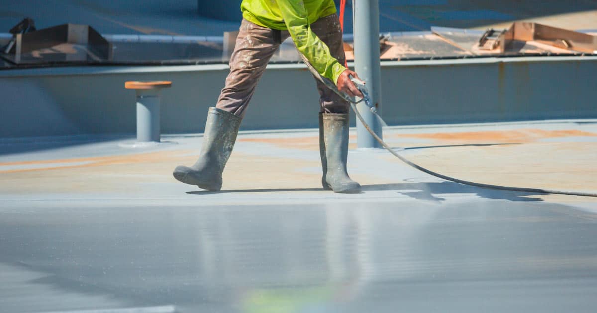 Man Spraying Foam Onto Flat Roof