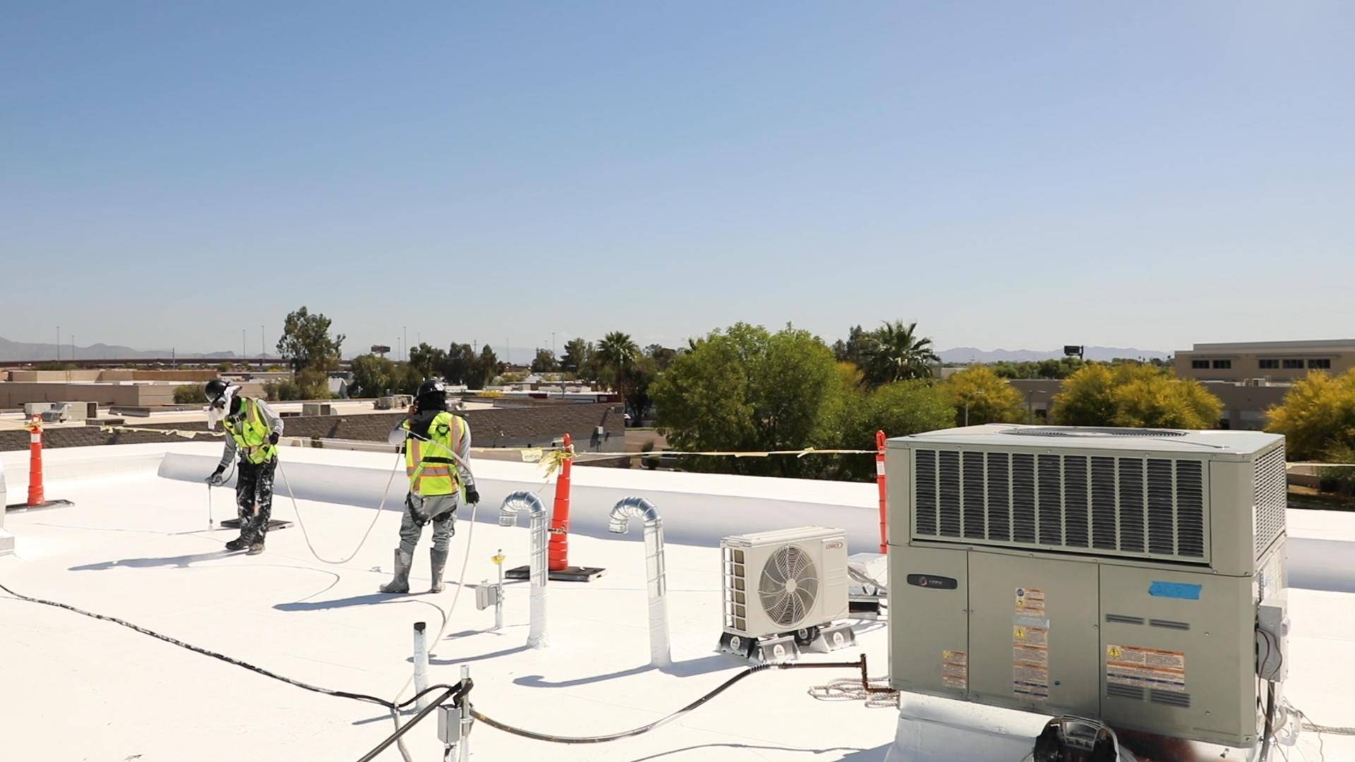 Workers Spraying White Coating on Roof