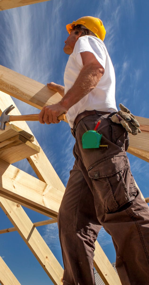 Roofer working on framing a house's roof