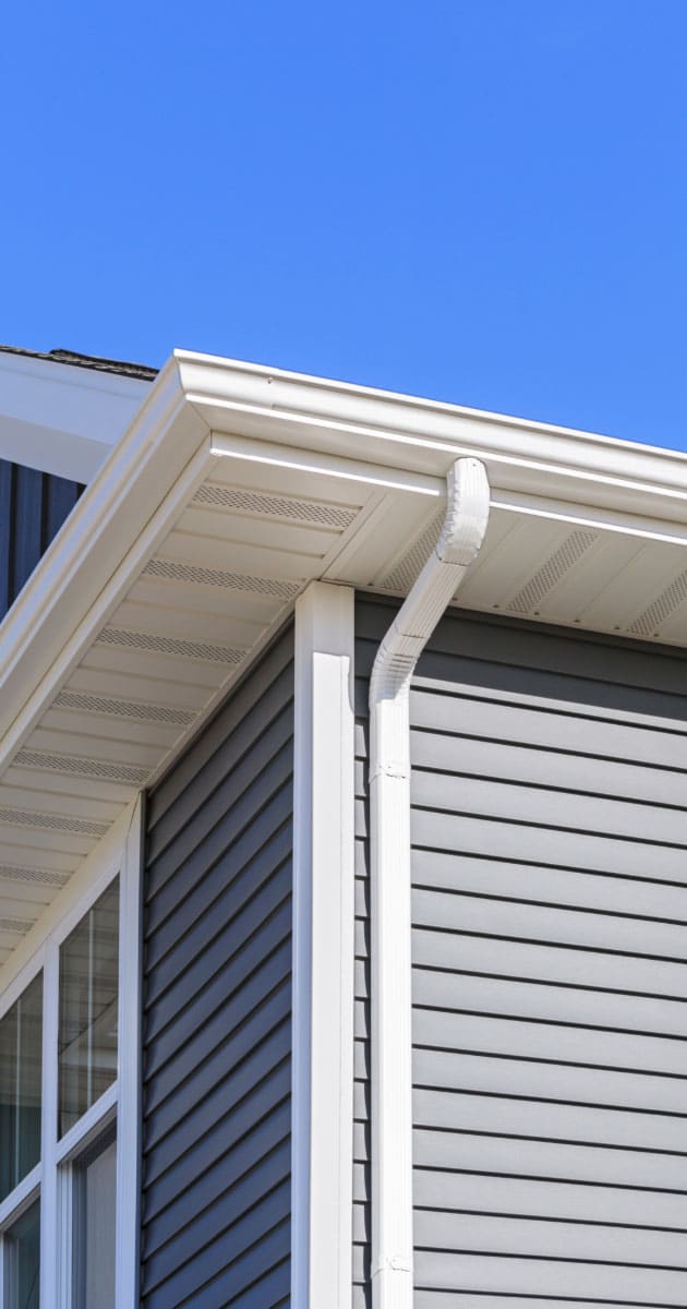 Two-story home with newly installed white gutters