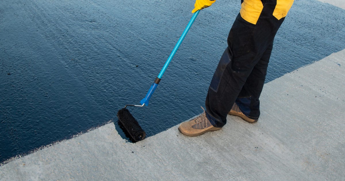 Roofer Applying Roof Coating by Roller
