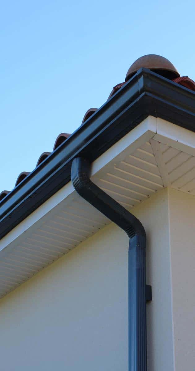 Newly installed black gutter system on house