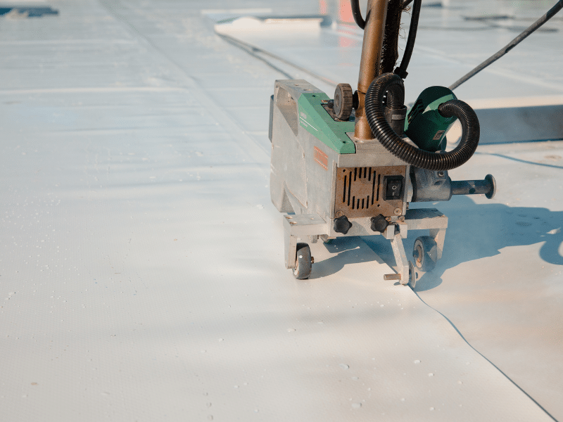 Machine putting down layers of TPO roof