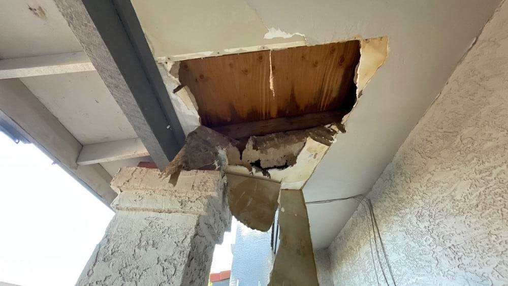 Failing aged underlayment exposed beneath tile roof during Phoenix repair