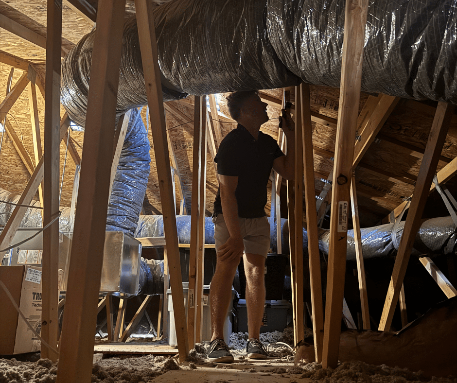 Professional roofer inspecting attic and ductwork during comprehensive Phoenix roof maintenance service