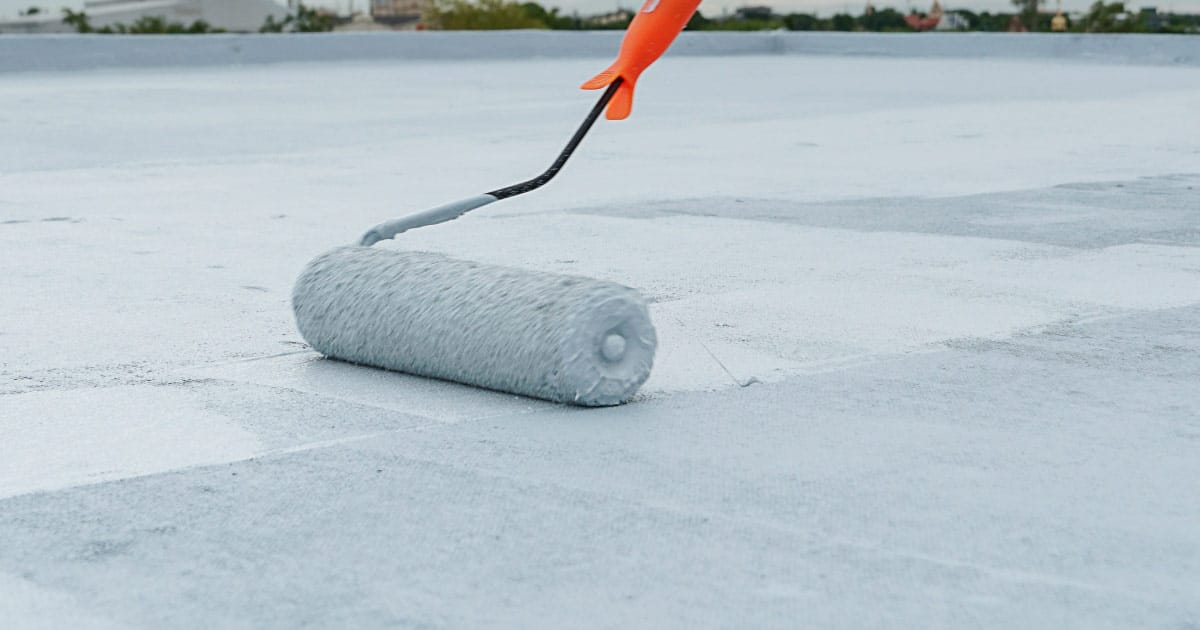 White roofing coating being applied on Gilbert roof